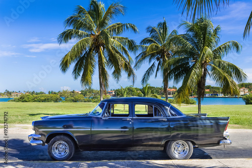 Schwarzer amerikanischer Oldtimer parkt unter blauem Himmel nahe des Strandes in Varadero Kuba - Serie Cuba Reportage 