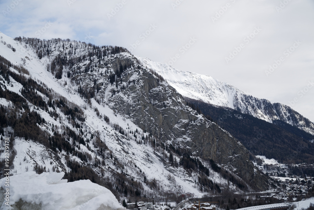 Canyon mountains covered with snow and winter forest near Mont Blanc Alpes, Italy
