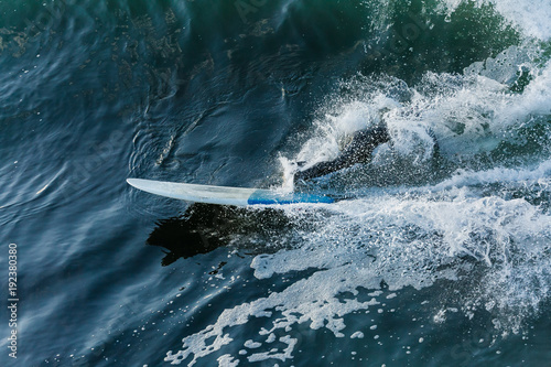 Surfer in large wave wipes out and falls off surf board