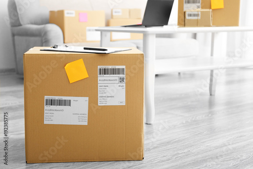 Parcel ready for shipment to customer on floor in home office. Startup business © Africa Studio