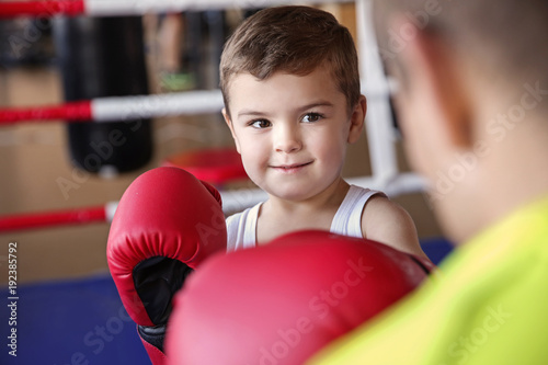 Little boy training with coach in boxing ring © Africa Studio