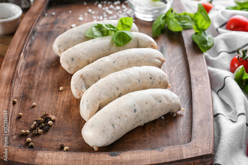Delicious white sausages on wooden board