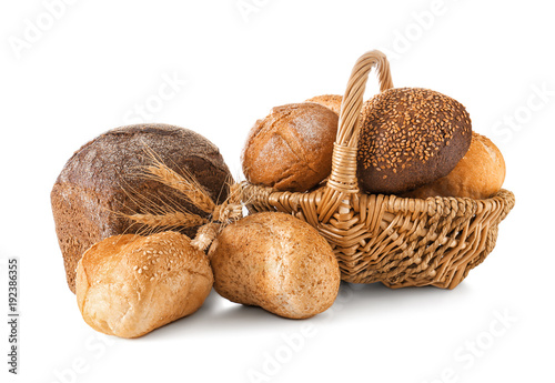 Composition with wicker basket and different bread isolated on white