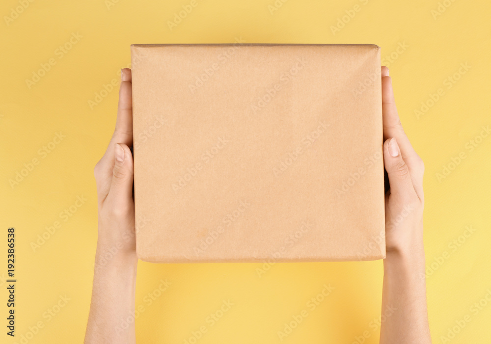 Woman holding parcel on color background Woman holding parcel on color background