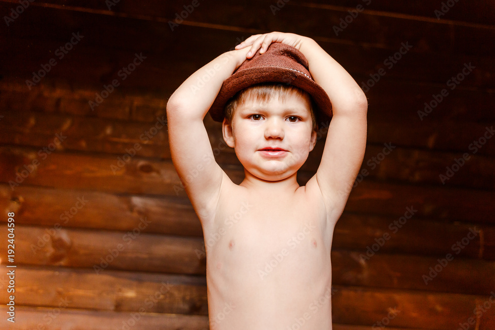 naked boy in a hat holding his head Stock Photo | Adobe Stock