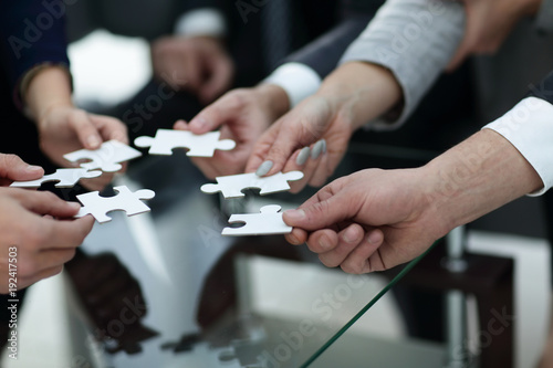 Business people holding jigsaw puzzle.