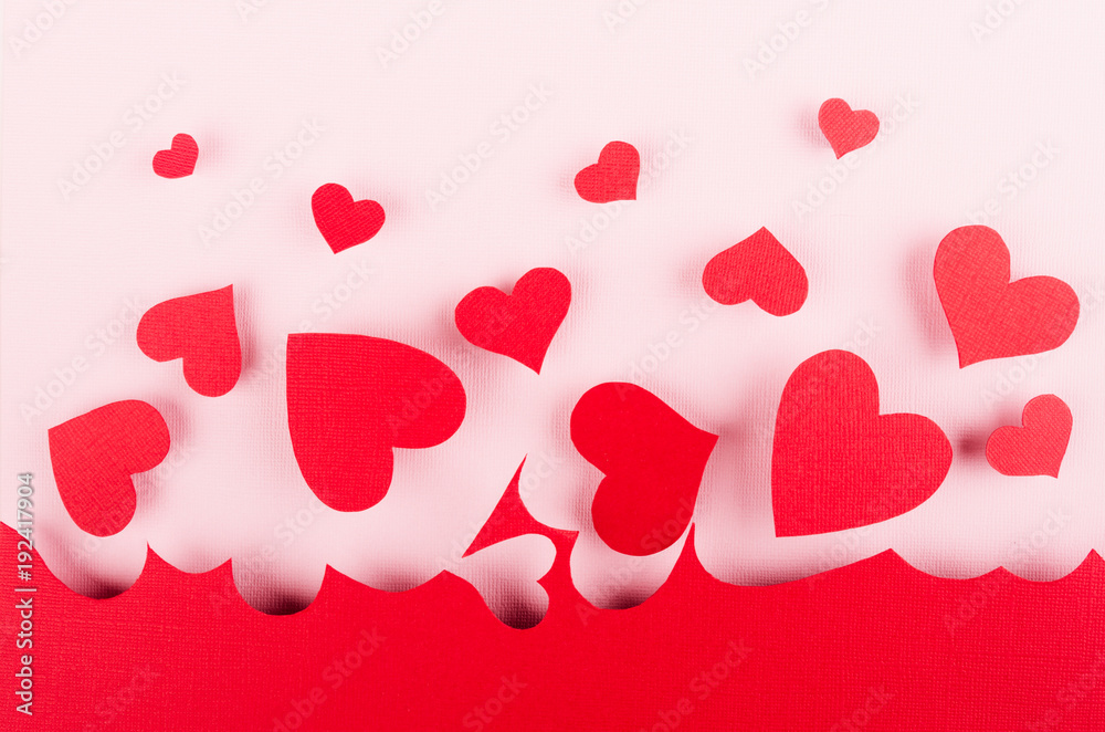 Red paper hearts fly on soft pink color background. Valentine day concept.