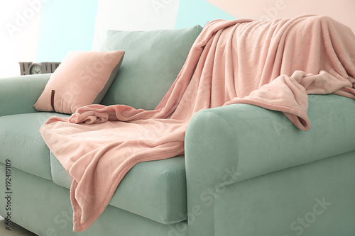 Comfortable mint couch with cushion and blanket in living room photo
