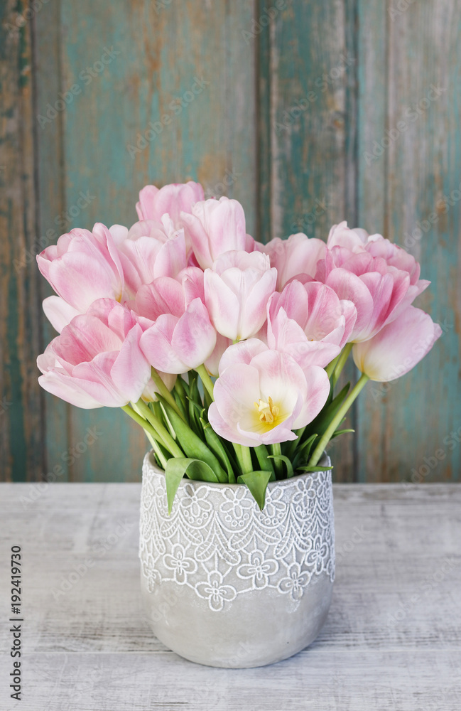 Bouquet of pink tulips, rustic wooden background.