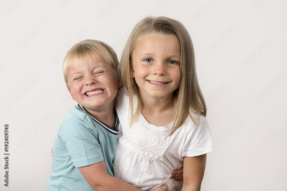 7 years old adorable blond happy girl posing with her little 3 years old brother smiling cheerful isolated on white background 7 years old adorable blond happy girl posing with her little 3 years old brother smiling cheerful isolated on white background