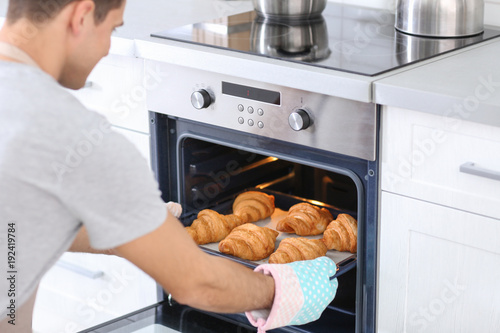 Man taking baking tray with...