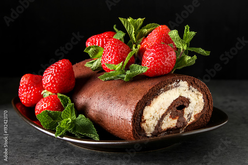 Delicious homemade chocolate cake with strawberries and mint. Dark background. Celebratory dinner.