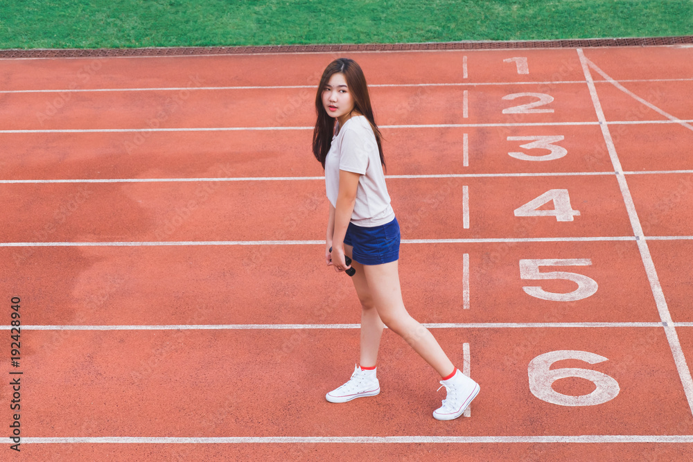 Fashion portrait of Hipster teen girl wear casual clothes,posing on running track.