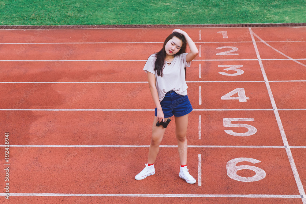 Fashion portrait of Hipster teen girl wear casual clothes,posing on running track.