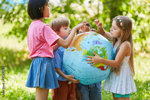 Kinder halten zusammen eine Weltkugel photo