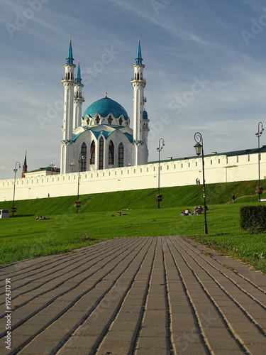 Widok Wielkiego Meczetu w Kazaniu, stolicy Tatarstanu w Federacji Rosyjskiej, na pierwszym planie brukowany chodnik wiedzie do zielonego wzgórza na którym jest meczet, błękitne niebo 