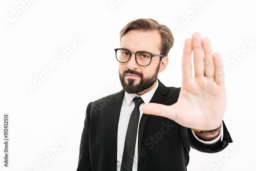 Serious businessman showing stop gesture.