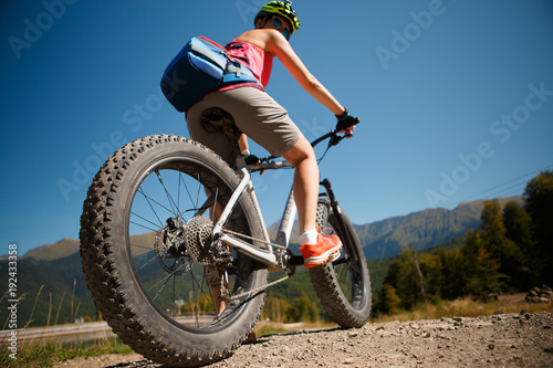 Fototapeta Naklejka Na Ścianę i Meble -  Photo of girl in helmet riding on mountain-bicycle