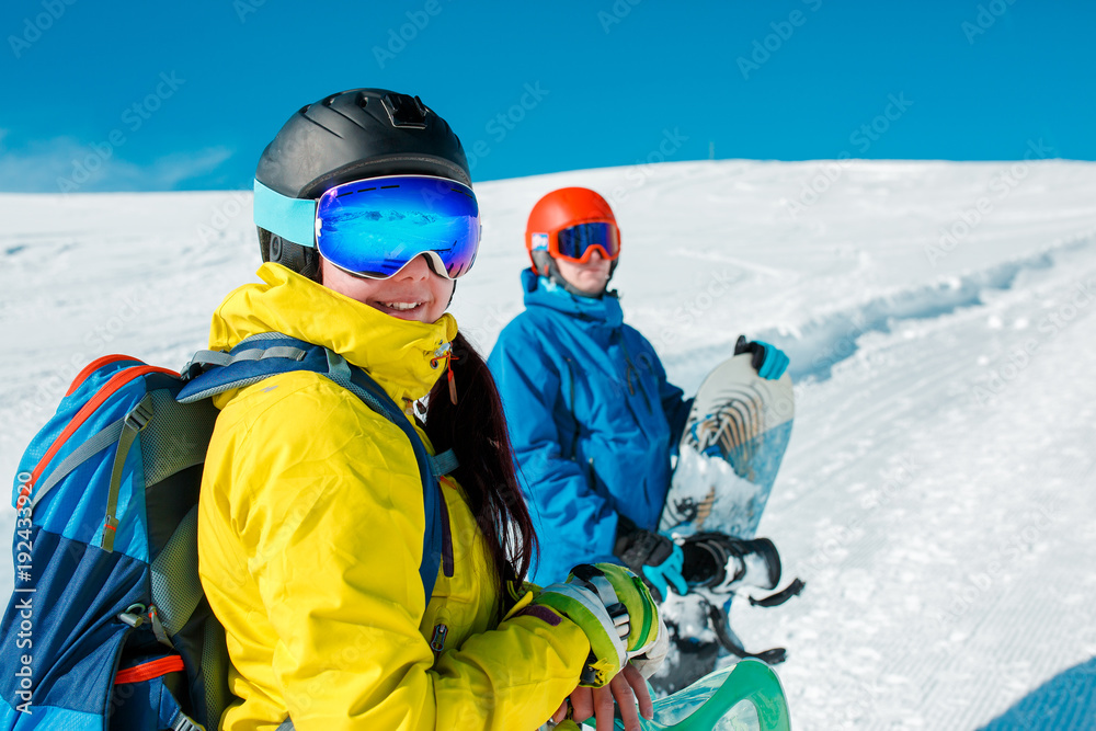 Image of happy couple with snowboard on background of snowy hills