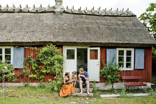 Family sitting on steps in Friseboda, Sweden photo