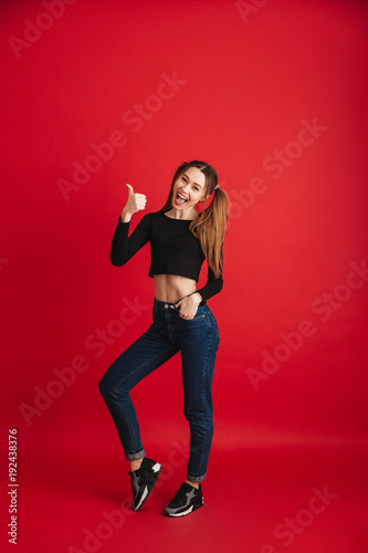 Funny young woman showing thumbs up.