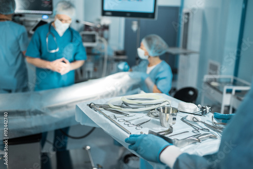 cropped image of doctor holding tray with medical tools for surgery