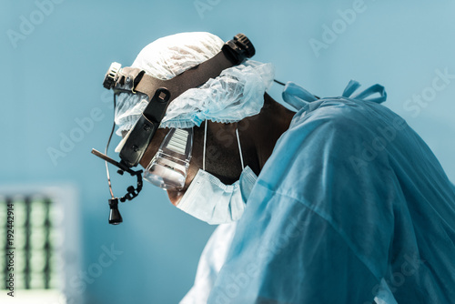 side view of african american surgeon in operating room photo