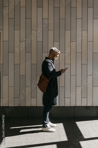 Man texting on street in Stockholm, Sweden