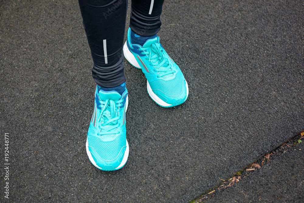 Close up of legs in running shoes standing on asphalt. Close up of legs in running shoes standing on asphalt.