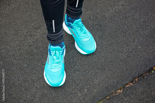 Close up of legs in running shoes standing on asphalt. © Dmytro Panchenko