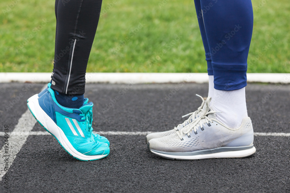 Cropped shot of a male and female legs in running shoes close to each other.