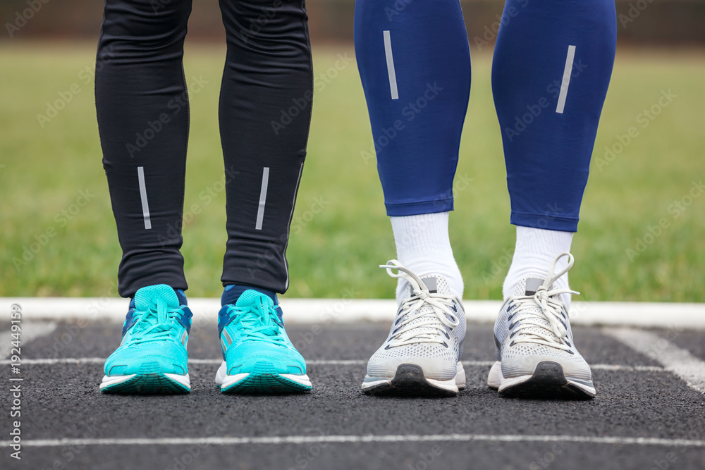 Fototapeta premium Front cropped view of two runners in running shoes.