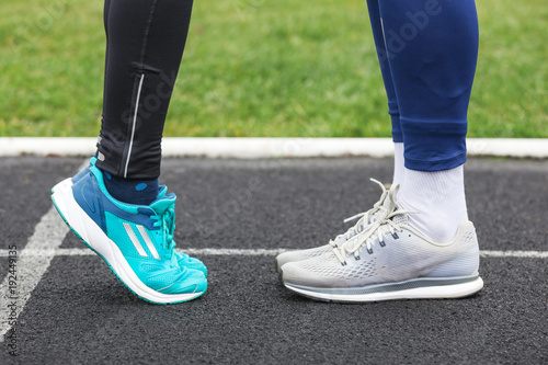 Cropped shot of a male and female legs in running shoes close to each other.