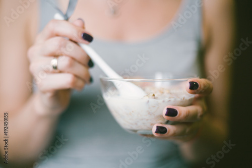 female hands with a spoon of granola