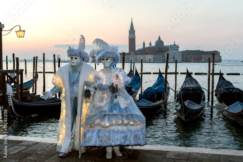 Couple of masks in marvellous ice blue costumes in front of Venetian gondolas - Carnival, Venice © phokrates