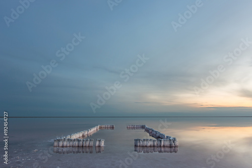 A beautiful light with a smooth sky over a salt lake with a smooth water and a reflection of the sky