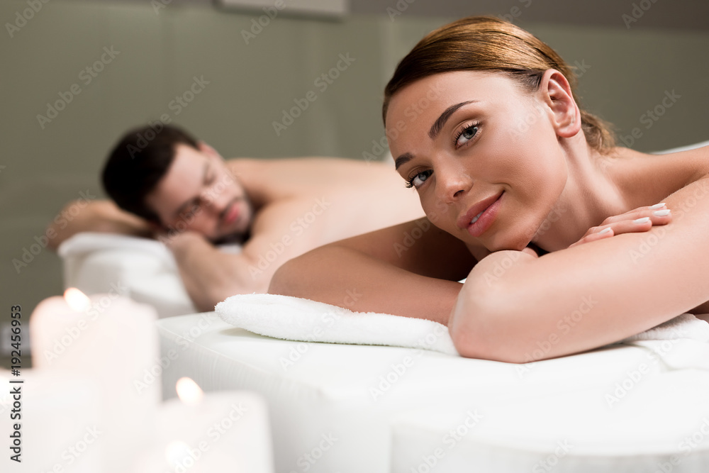 young woman smiling at camera while having massage in spa salon young woman smiling at camera while having massage in spa salon