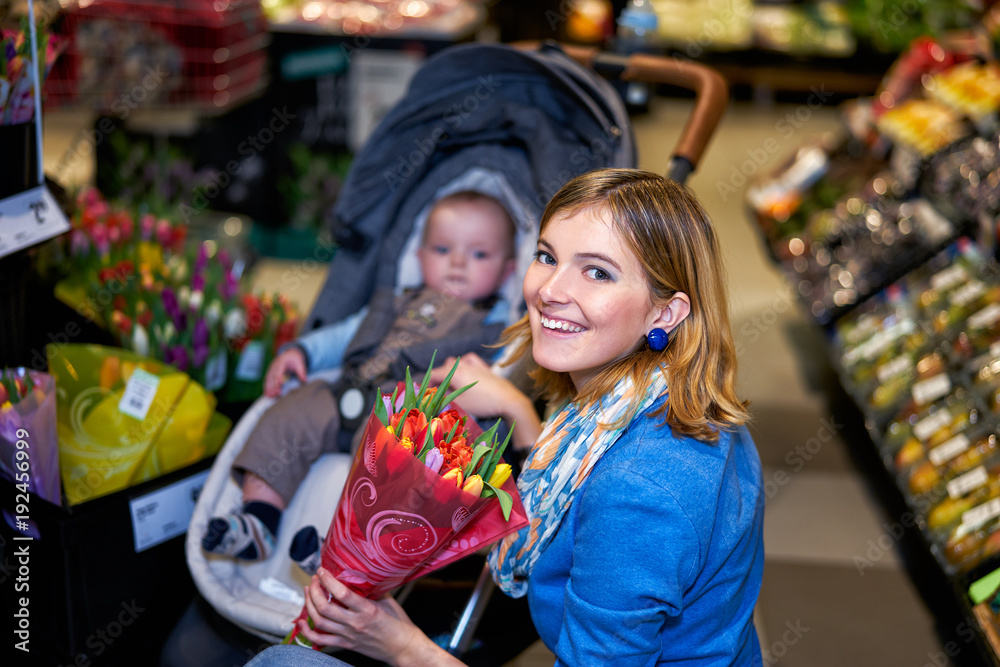 Happy young woman with tulips in shop