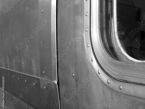 Genietete Bleche aus Aluminium eines alten amerikanischen Wohnwagen Klassiker für Camping und Vanlife in Silber mit Fenster in der Hansestadt Hamburg, fotografiert in neorealistischem Schwarzweiß