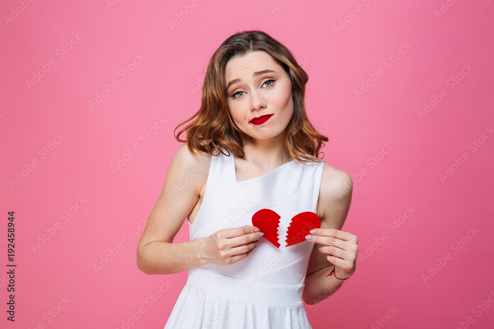 Confused woman holding broken heart. Looking camera. Confused woman holding broken heart. Looking camera.