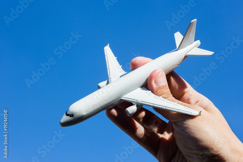 Airplane model in hand on sunny sky. Concepts of travel, transportation, transport, dreaming about holidays