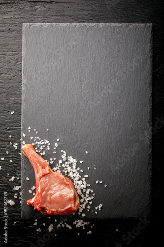 Meat Raw Fresh Mutton on the bone on a slate board black background Top View Copy space for Text