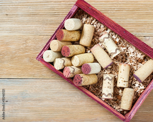 Wine corks close up, bang of the bottle in vintage wooden box. Corks on old wood table. Top view.