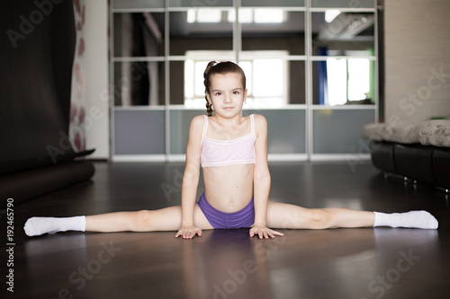 little caucasian girl sitting on a twine.