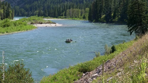 a wide shot of fishing dift boat navigating the snake river in wyoming, usa photo