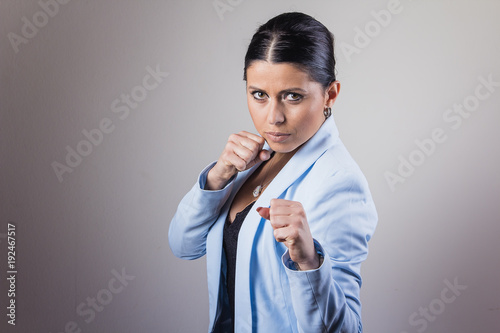 Young corporate lady strikes back, ready to fight and punch with her fists clenched