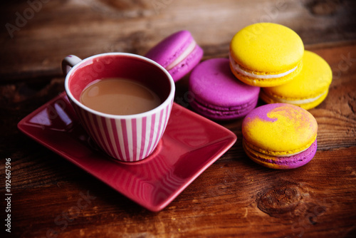 colored macaroons and a Cup of coffee on a wooden table, color macaroons ultraviolet