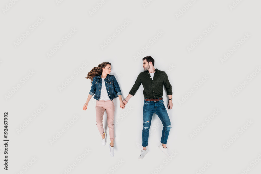 top view of stylish young couple holding hands isolated on white