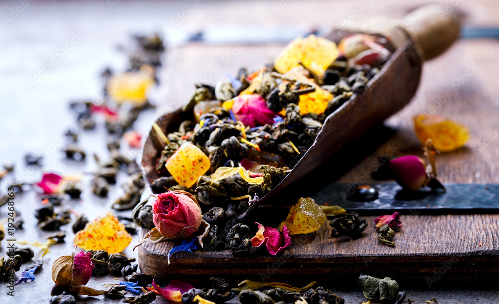Dry Tea on the basis of Green with fruits and  rose petals, cornflower and calendula on a wooden background
