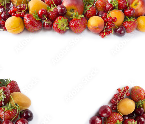 Red and yellow fruits on white background. Ripe apricots  red currants  cherries and strawberries. Sweet and juicy fruits  at border of image with copy space for text. Various fresh summer.